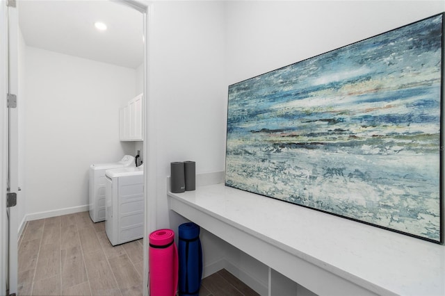 laundry room featuring cabinets, light hardwood / wood-style flooring, and washer and dryer