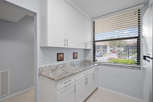 kitchen featuring white cabinets and light tile patterned floors