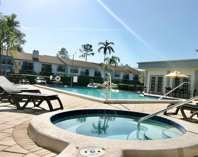 view of swimming pool with french doors, a patio, and a hot tub