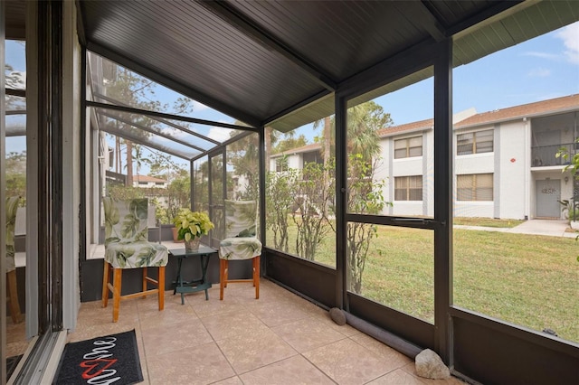 sunroom featuring lofted ceiling and a healthy amount of sunlight