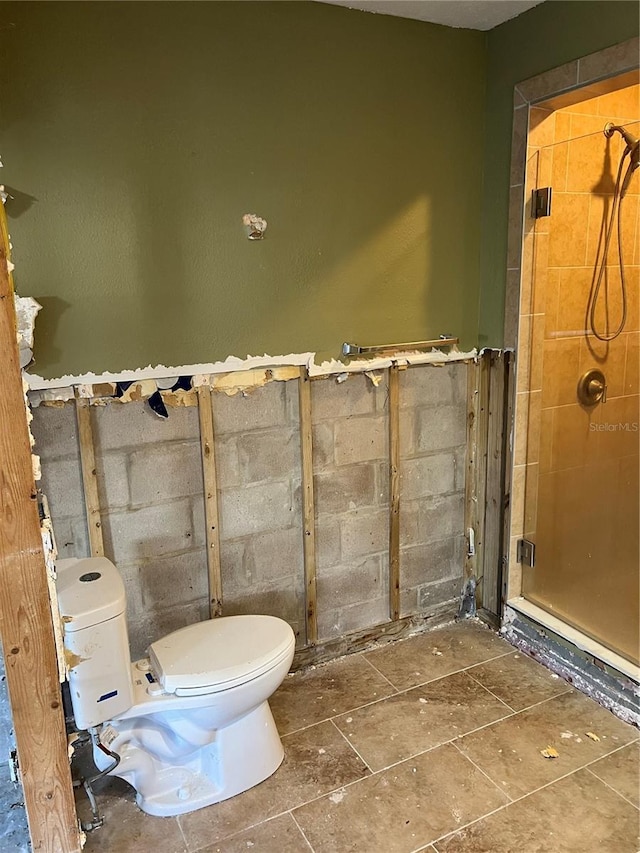 bathroom with a tile shower and toilet