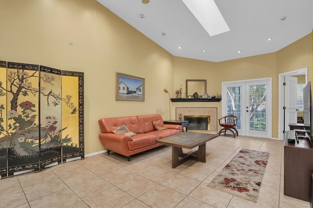 living room featuring a tile fireplace, a towering ceiling, a skylight, and light tile patterned flooring