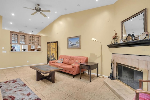 tiled living room featuring a fireplace, vaulted ceiling, and ceiling fan