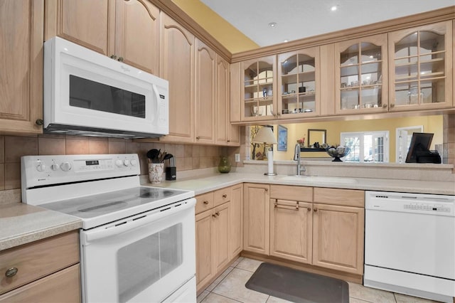 kitchen with light tile patterned floors, white appliances, tasteful backsplash, and sink