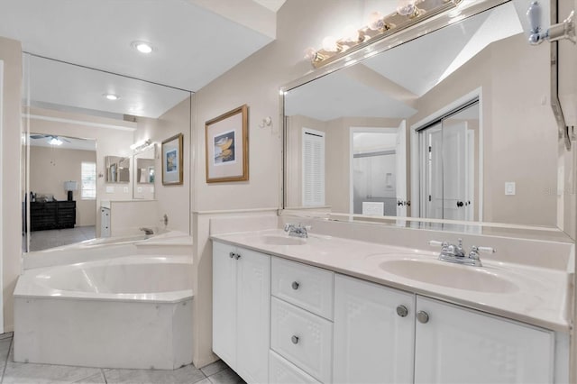 bathroom featuring a bathtub, vanity, and tile patterned flooring