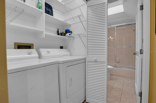 laundry area featuring washing machine and dryer and light tile patterned flooring