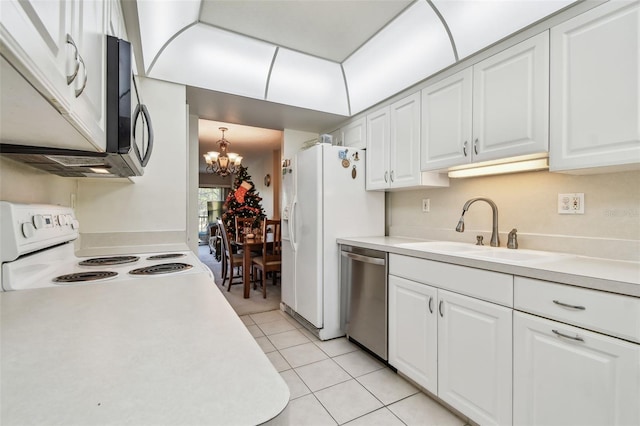 kitchen featuring white cabinets, sink, light tile patterned floors, stainless steel appliances, and a chandelier