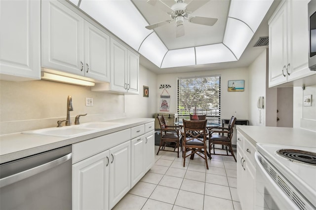 kitchen with appliances with stainless steel finishes, ceiling fan, sink, light tile patterned floors, and white cabinets