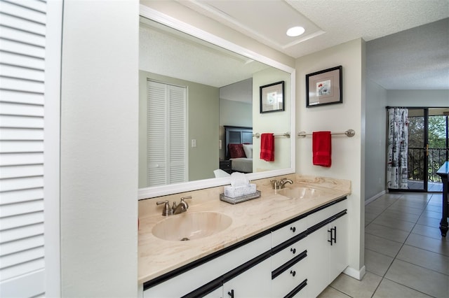 bathroom featuring tile patterned flooring, vanity, and a textured ceiling