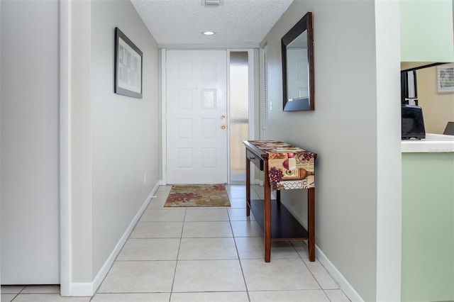 corridor with light tile patterned floors and a textured ceiling