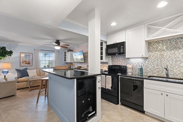 kitchen featuring black appliances, white cabinets, sink, wine cooler, and a kitchen bar