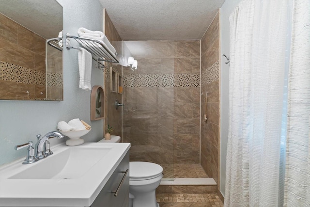 bathroom with vanity, curtained shower, toilet, and a textured ceiling