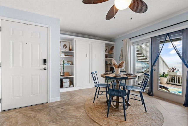 tiled dining room with ceiling fan, built in features, and crown molding