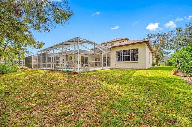 back of house with a lawn and glass enclosure