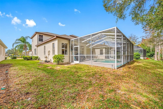 rear view of house featuring a lanai and a lawn