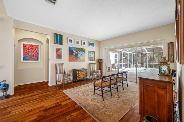 dining space with a textured ceiling and dark hardwood / wood-style floors