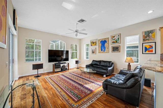 living room featuring wood-type flooring and ceiling fan