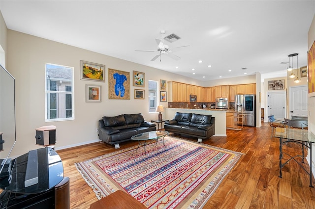 living room featuring hardwood / wood-style flooring and ceiling fan