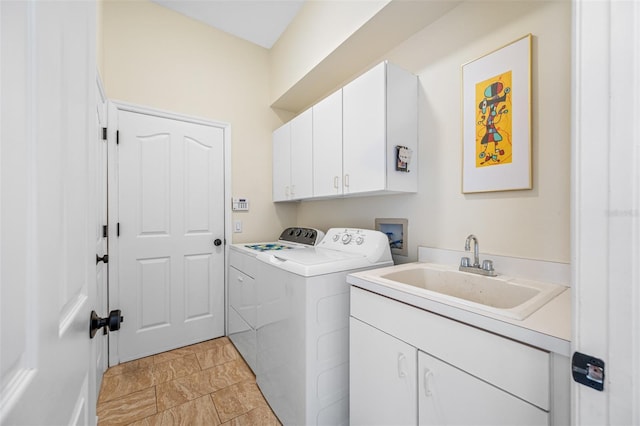 clothes washing area with washer and dryer, sink, and cabinets