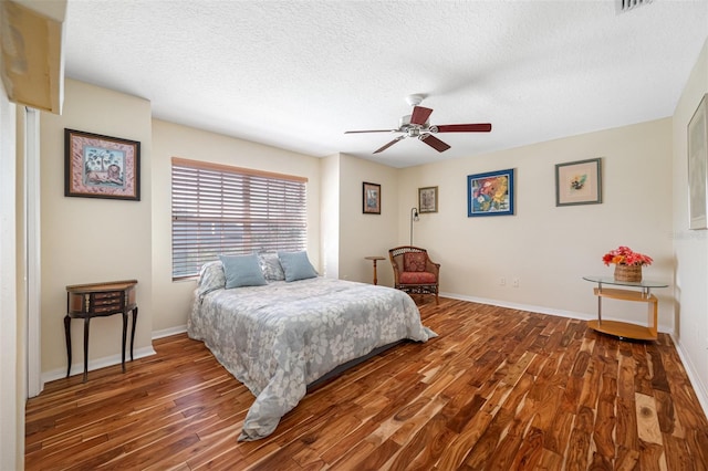 bedroom featuring hardwood / wood-style floors, ceiling fan, and a textured ceiling