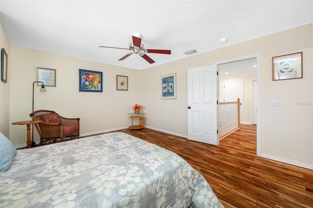 bedroom with ceiling fan, a textured ceiling, and hardwood / wood-style flooring