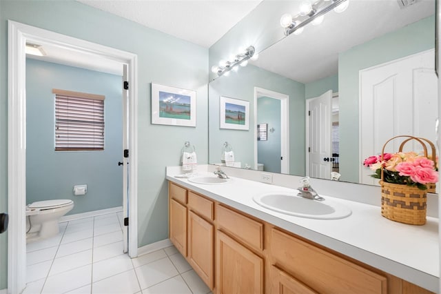 bathroom with tile patterned flooring, vanity, and toilet