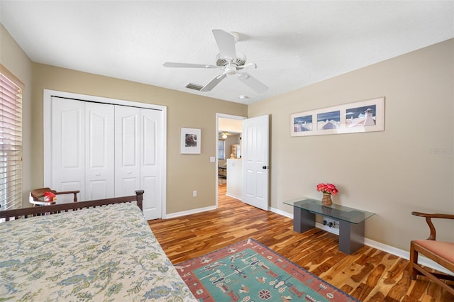 bedroom with ceiling fan, a closet, wood-type flooring, and a textured ceiling