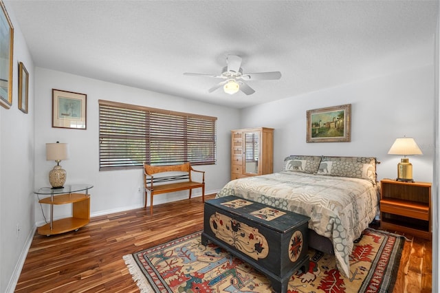 bedroom with ceiling fan, dark hardwood / wood-style flooring, and a textured ceiling