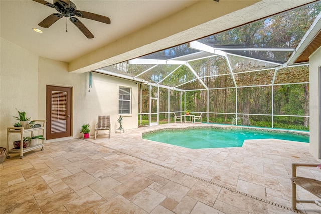 view of swimming pool with a patio, glass enclosure, and ceiling fan