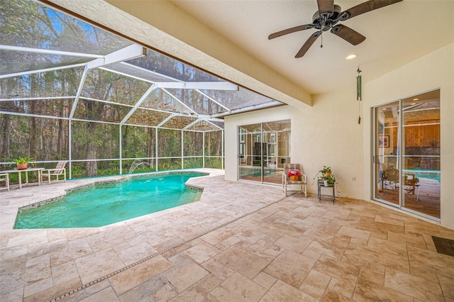 view of pool featuring glass enclosure, ceiling fan, and a patio