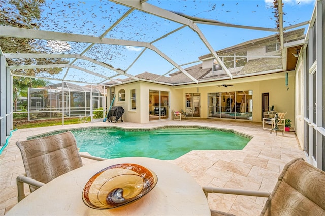 view of pool with a lanai, a patio area, ceiling fan, and grilling area