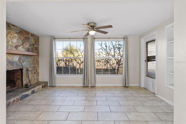 unfurnished living room with ceiling fan, a fireplace, and light tile patterned floors