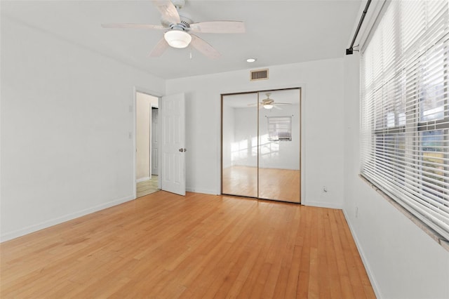 unfurnished bedroom featuring light hardwood / wood-style floors, a closet, and ceiling fan