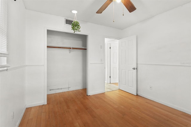 unfurnished bedroom featuring wood-type flooring, a closet, and ceiling fan