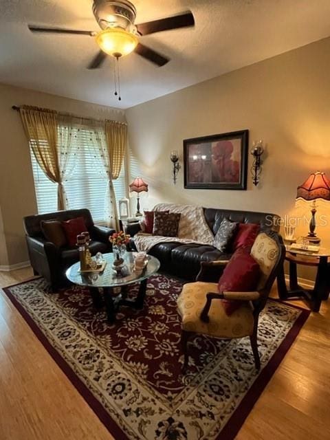 living room with hardwood / wood-style flooring and ceiling fan