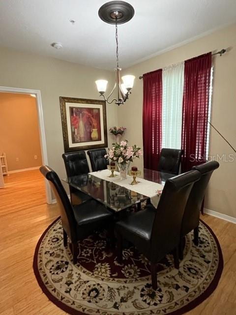 dining space with hardwood / wood-style flooring and an inviting chandelier