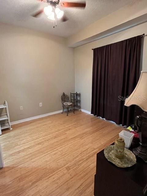 interior space featuring ceiling fan, hardwood / wood-style floors, and a textured ceiling