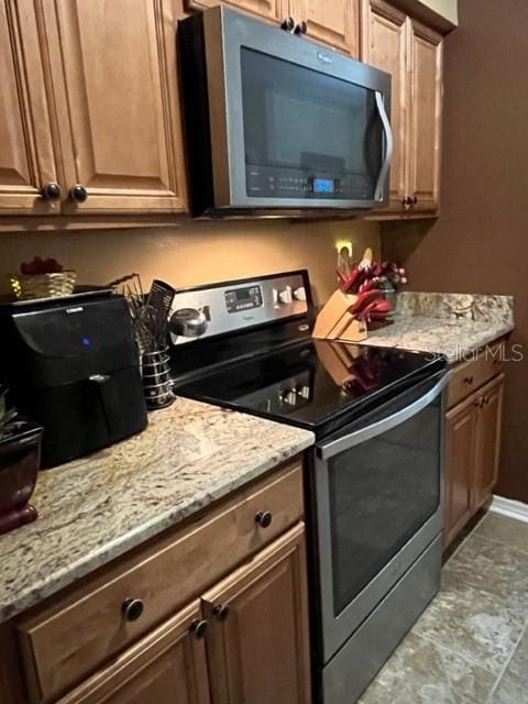 kitchen with light stone counters and stainless steel appliances