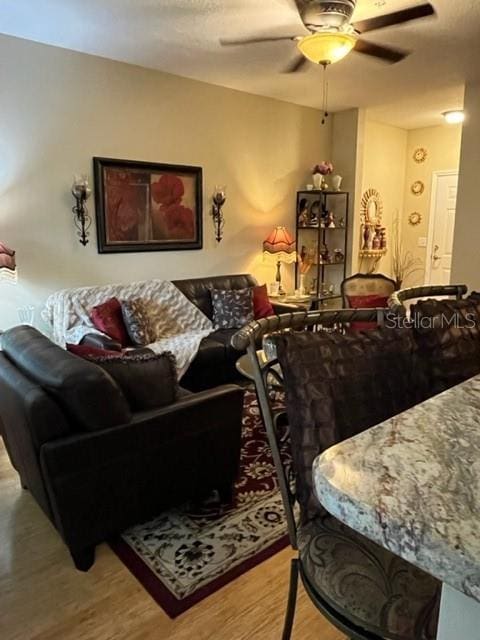 living room featuring light wood-type flooring and ceiling fan