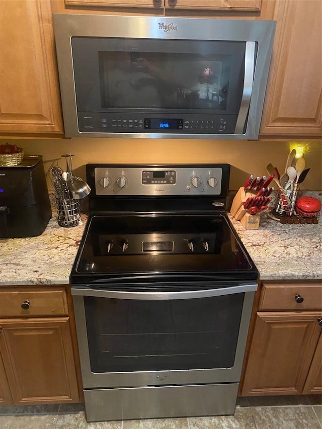 kitchen featuring light stone countertops and appliances with stainless steel finishes