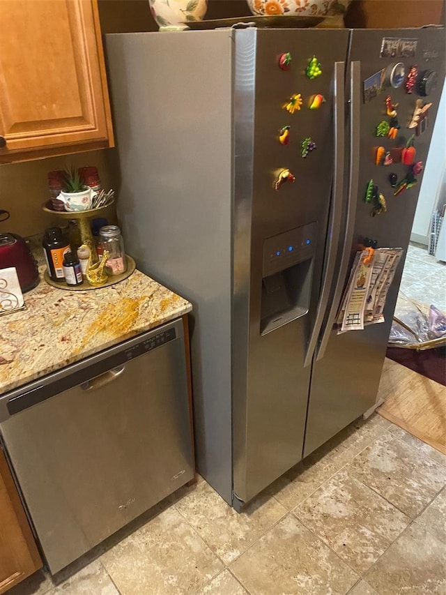 kitchen with light stone countertops and appliances with stainless steel finishes