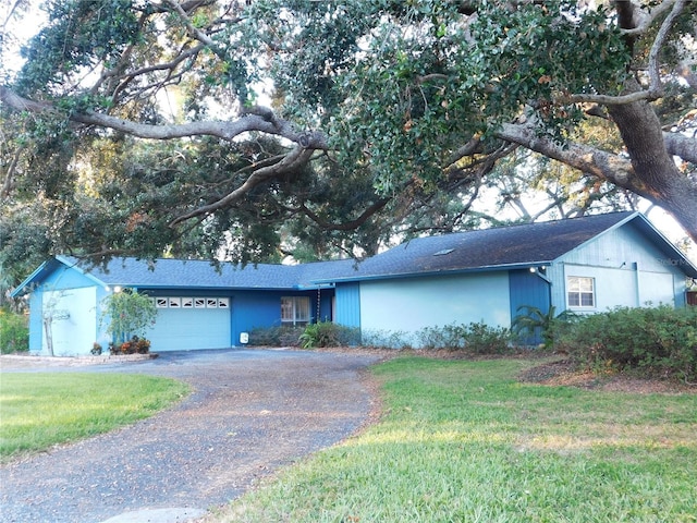 ranch-style house featuring a front lawn and a garage