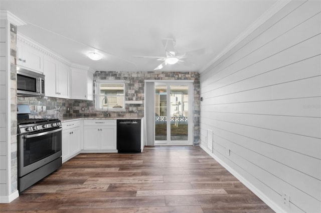 kitchen featuring white cabinetry, wooden walls, dark hardwood / wood-style floors, and appliances with stainless steel finishes