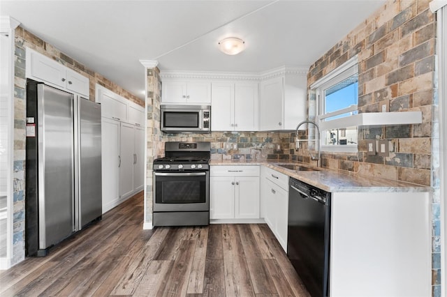 kitchen with appliances with stainless steel finishes, dark hardwood / wood-style flooring, backsplash, sink, and white cabinets