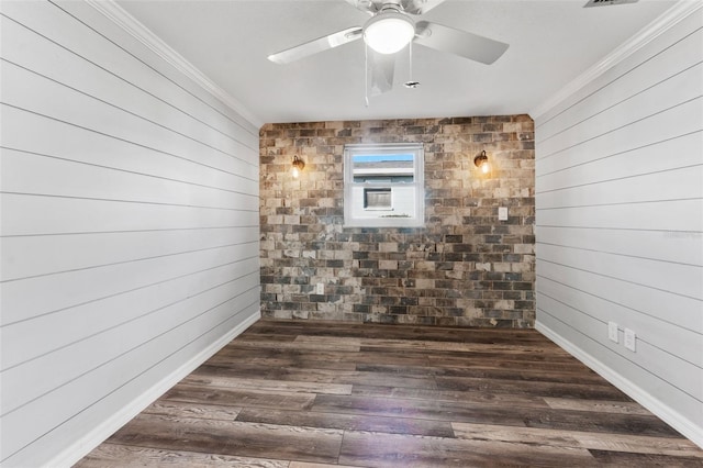 spare room with dark hardwood / wood-style flooring, crown molding, ceiling fan, and wooden walls