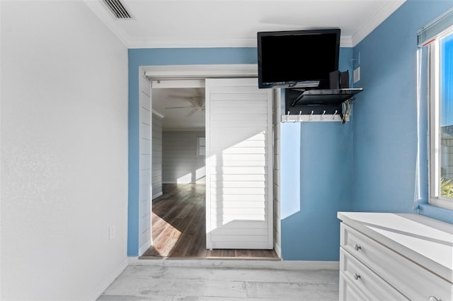 interior space with light hardwood / wood-style floors, a closet, and ornamental molding