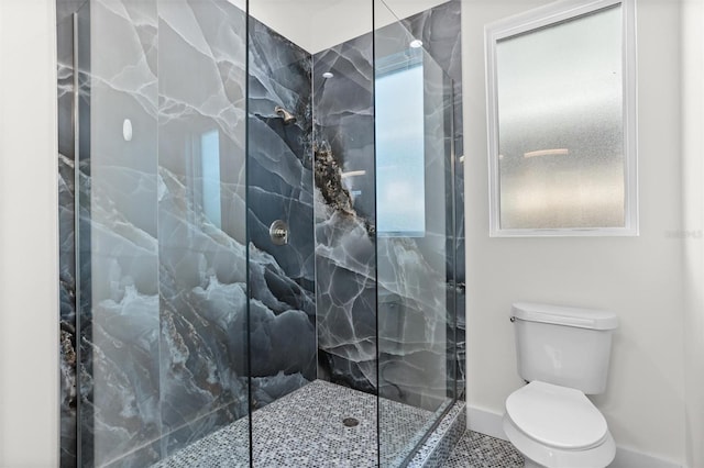 bathroom featuring tiled shower and toilet