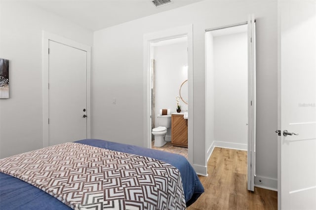 bedroom featuring wood-type flooring and connected bathroom