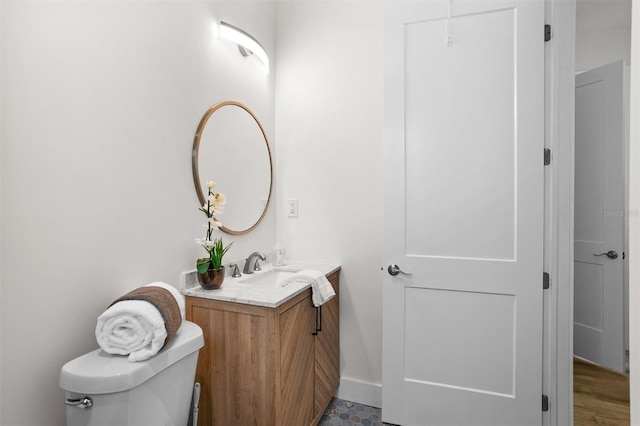 bathroom with wood-type flooring, vanity, and toilet