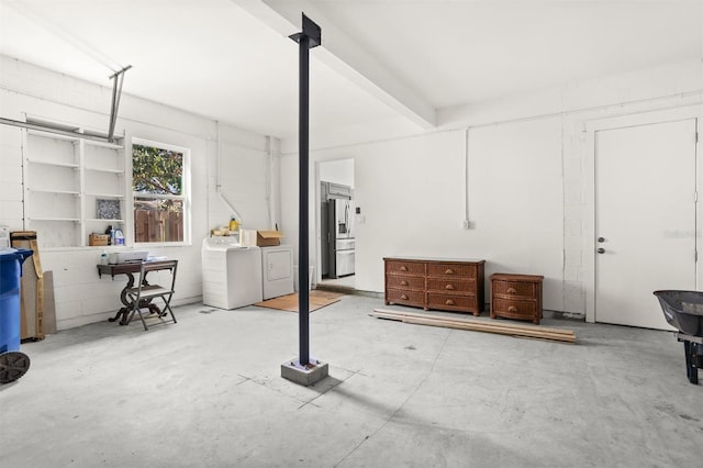 basement with stainless steel fridge and separate washer and dryer